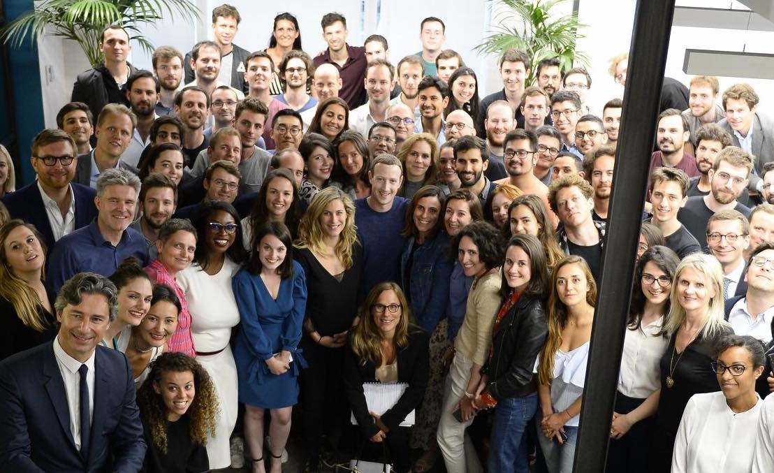 Image of the Facebook Paris staff taken from above, with Mark Zuckerberg in the middle smiling creepily at the camera