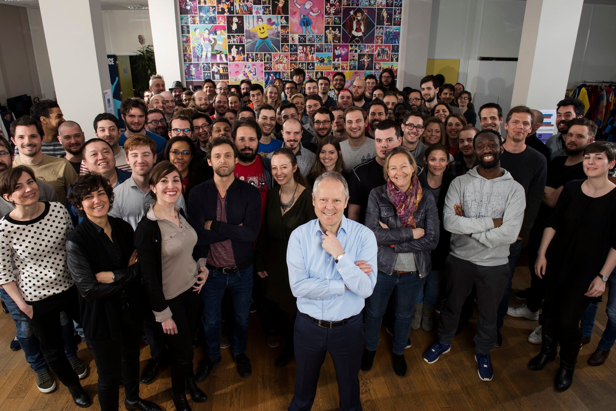 Yves Guillemot and a room full of Ubisoft employees posing for a group picture in the office.